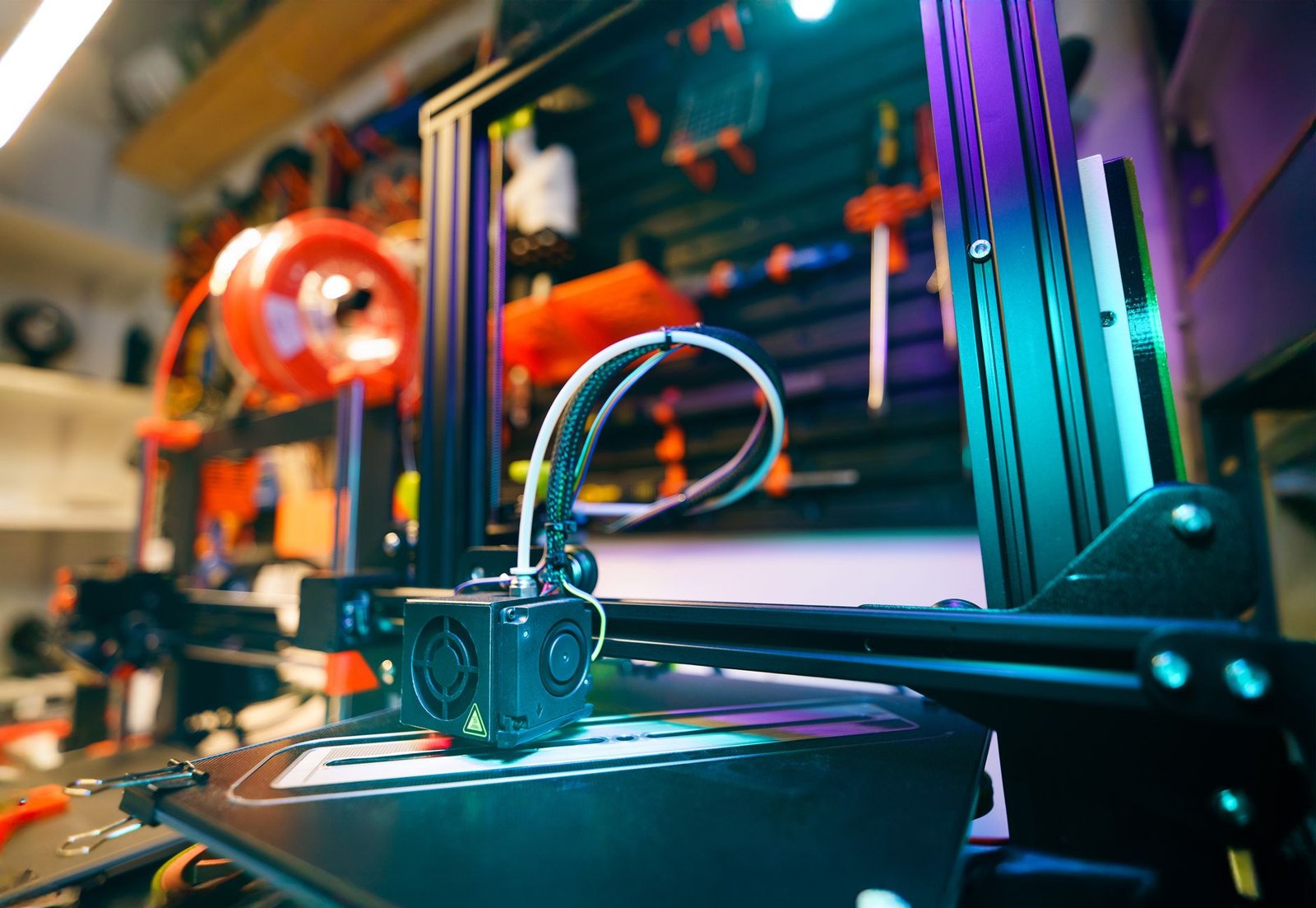 A close-up shot of a 3D printer in a vibrant and modern workshop environment.