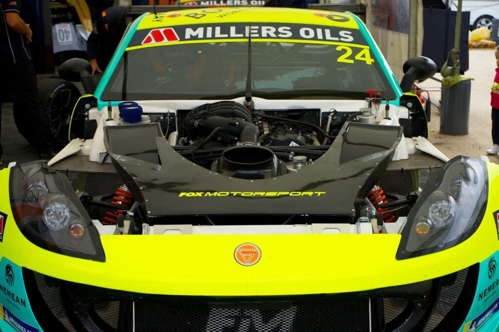Detailed view of a race car engine and front end at Silverstone motorsport event.