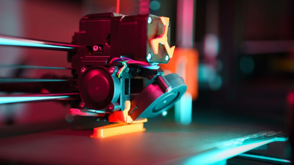 Close-up of a 3D printer in action with neon lighting, showcasing technology in prototyping.