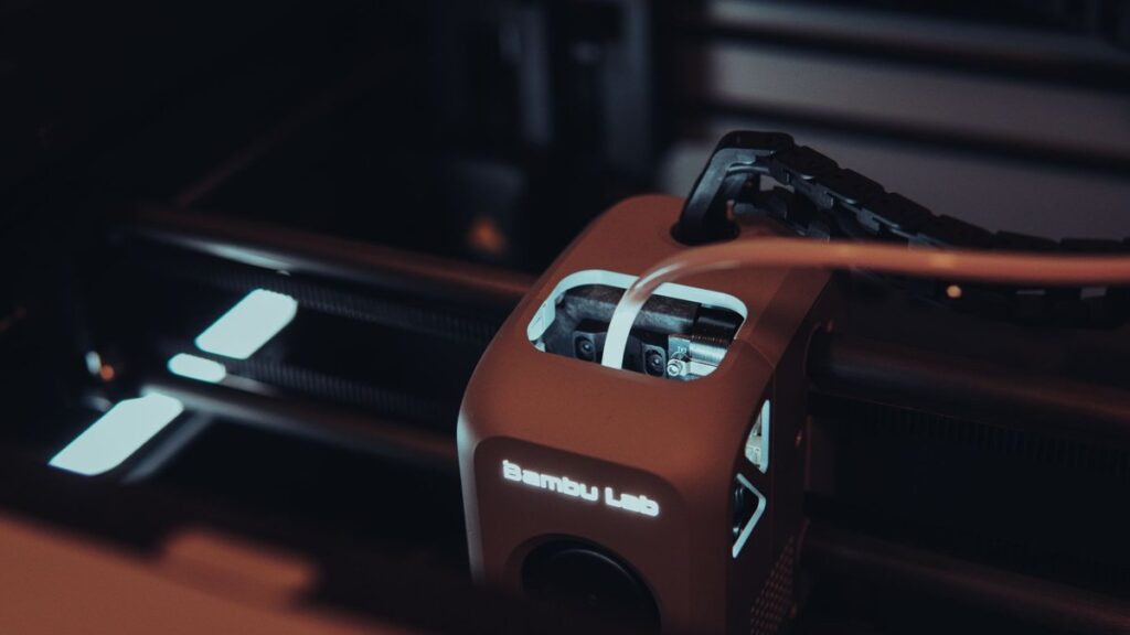 Detailed view of a 3D printer mechanism in a dark setting, highlighting technology.