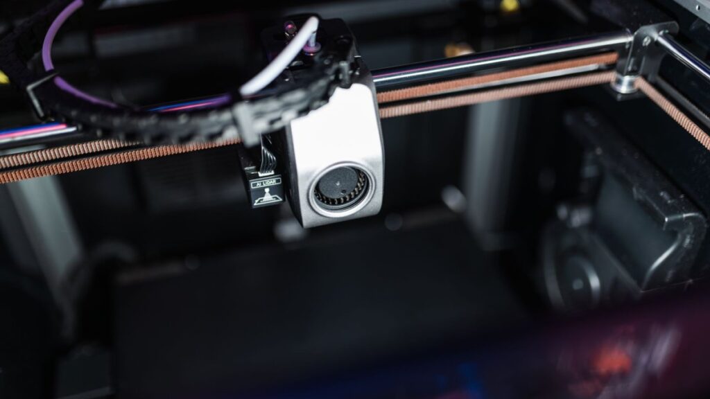 Detailed image showcasing the intricate components of a high-tech 3D printer in action.