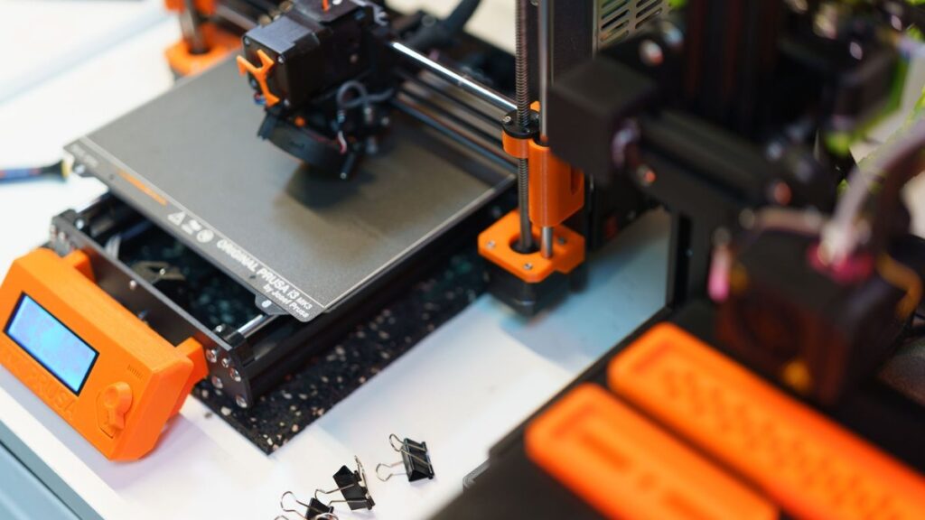 Detailed view of a 3D printer in a modern industrial setting, showcasing technology and creativity.
