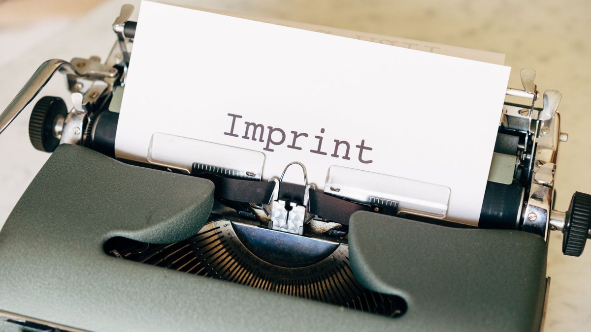 Close-up of a vintage typewriter with the word 'Imprint' on paper, evoking a classic retro feel.