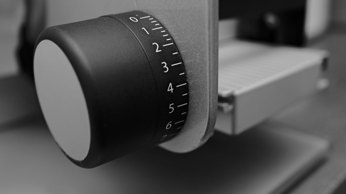 Detailed monochrome close-up of a kitchen appliance knob with numbers, capturing industrial design.